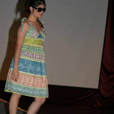 Student wearing multi-colored sun dress, sandals and sun glasses.