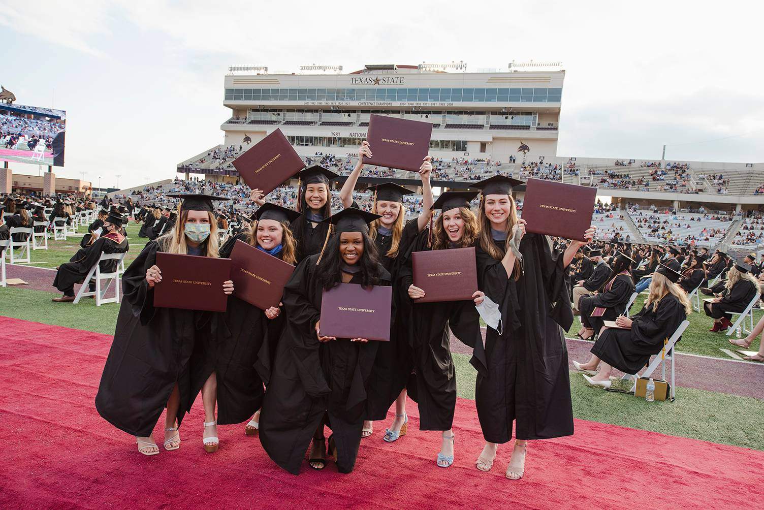 group of graduates holding diplomas