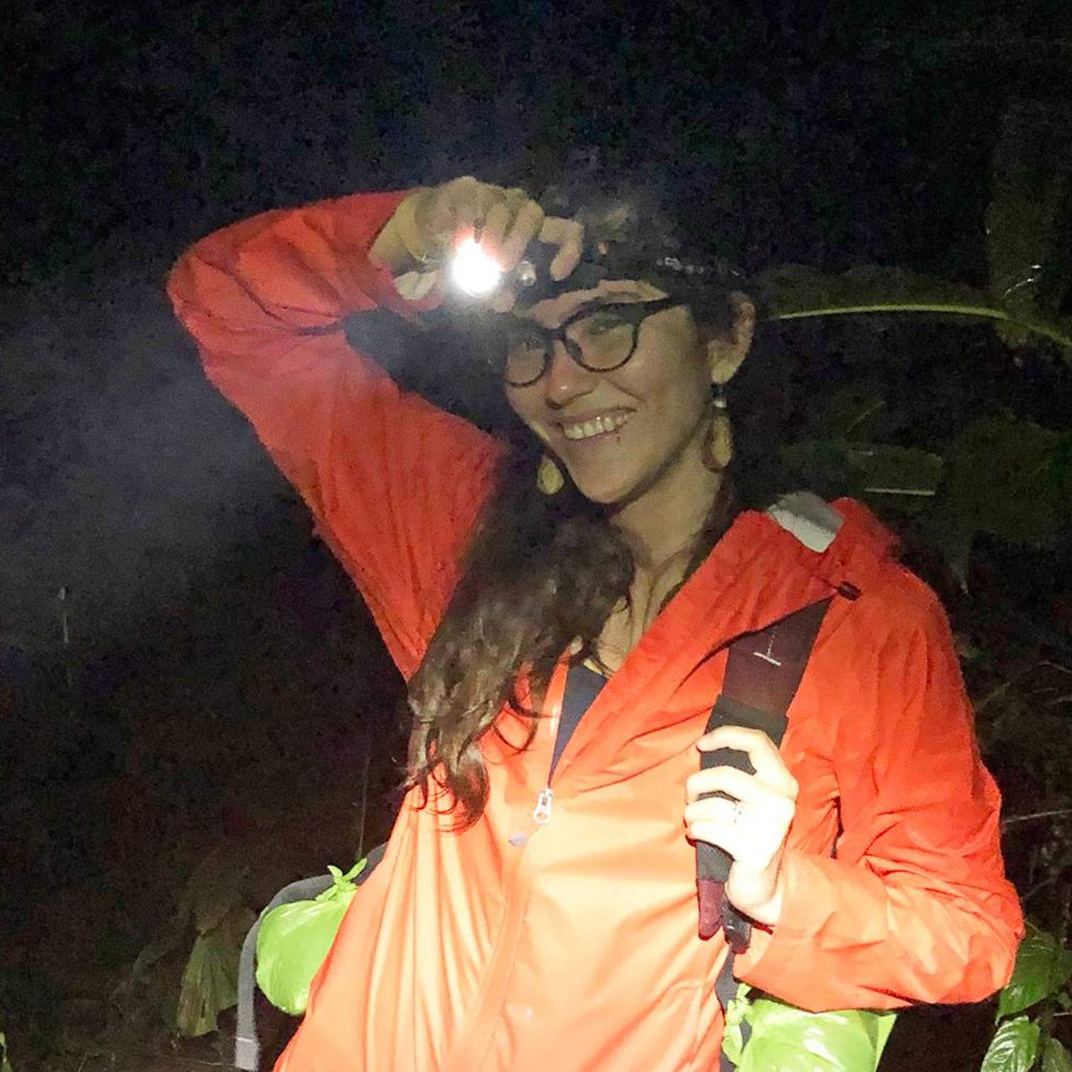 student in forest with headlamp
