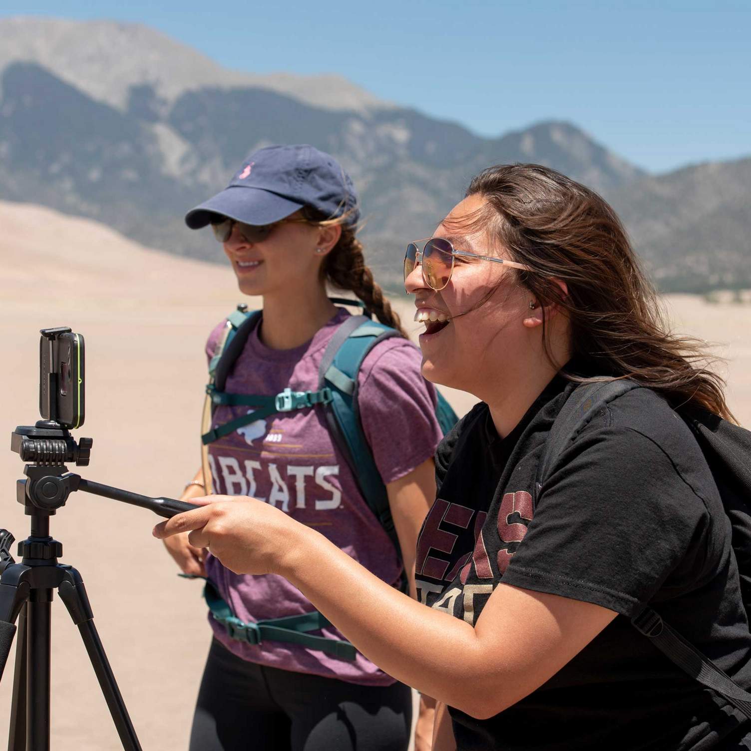 A student laughs while taking a picture with a tripod