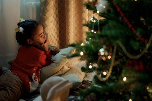 young girl looking at christmas tree