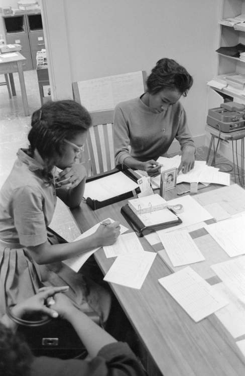 two ladies sitting at desk filling out paperwork