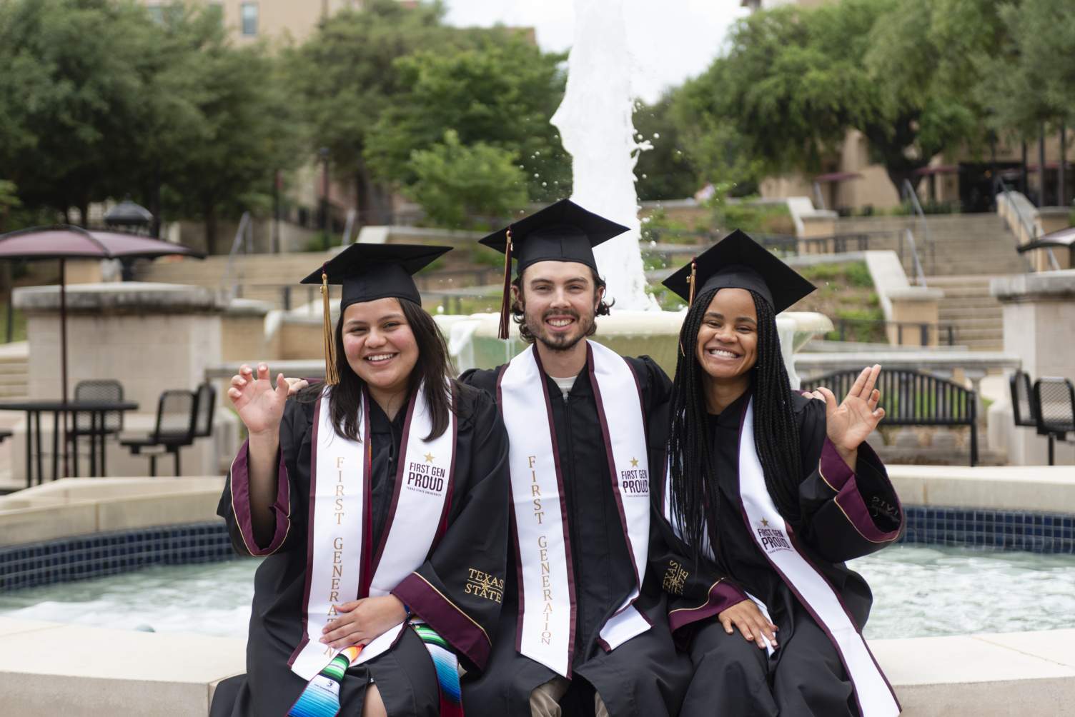 Image depicts three Texas State Students posing with the First-Gen Proud graduation stoles 