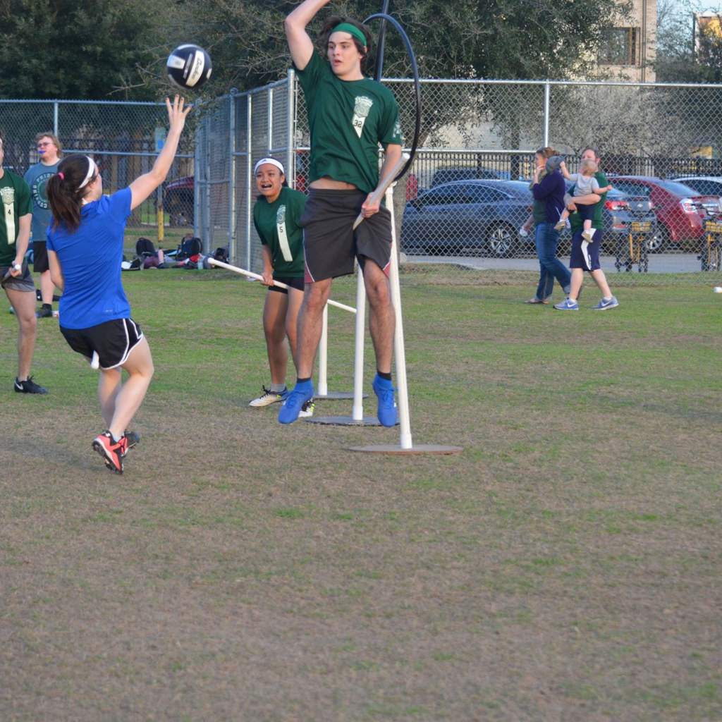 Quidditch player shoots ball (quaffle) at hoop while another defends hoop