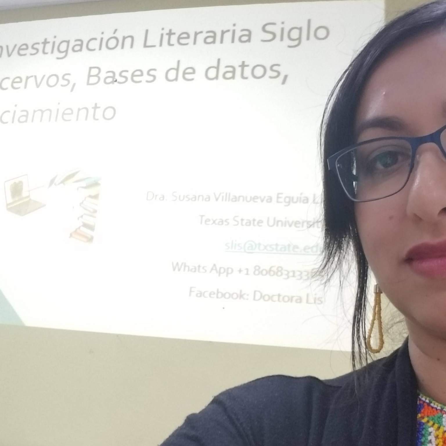 Photo of Dr. Susana Lis in front of screen with Powerpoint slide