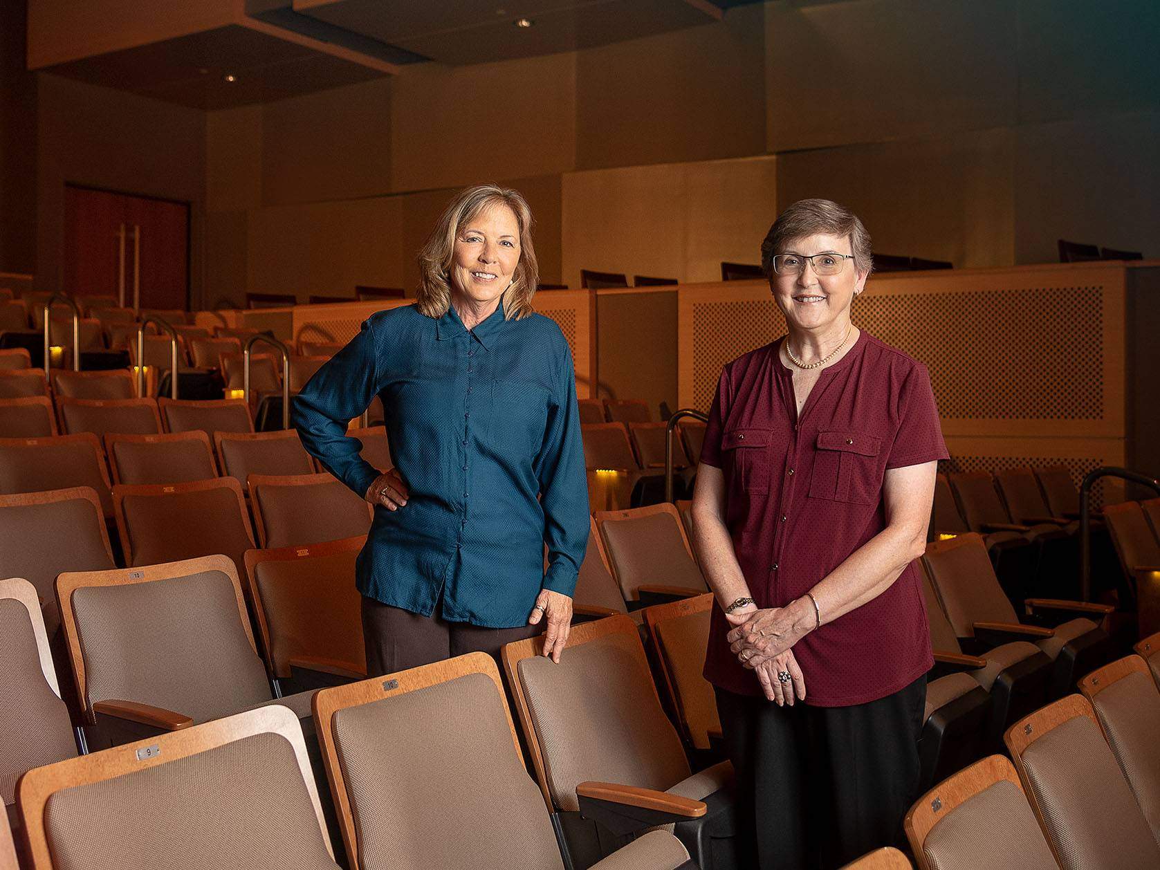 two women standing in theater and smiling