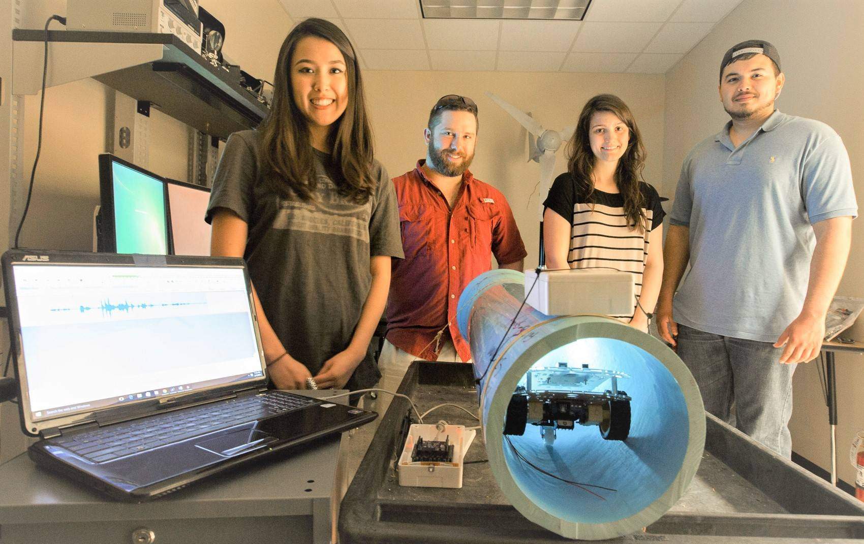 Four students research team standing with project