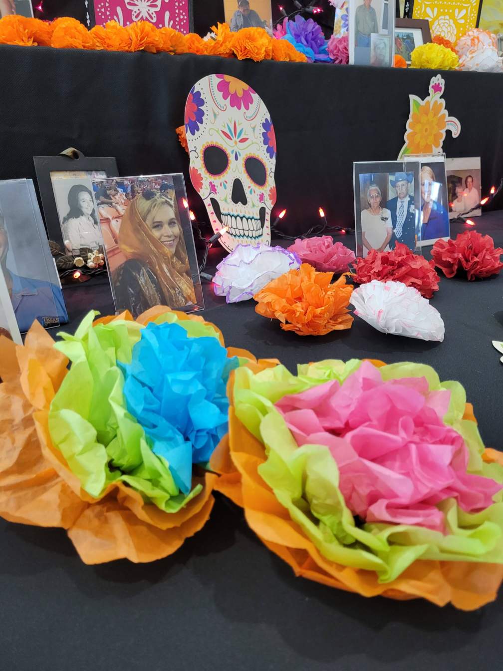 flowers and pictures on the Dia de los Muertos altar