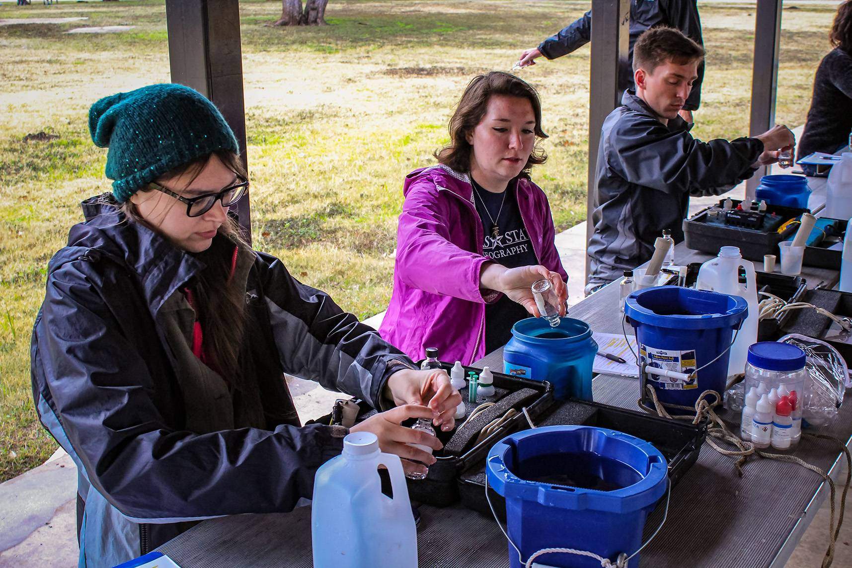three people working on testing water quality