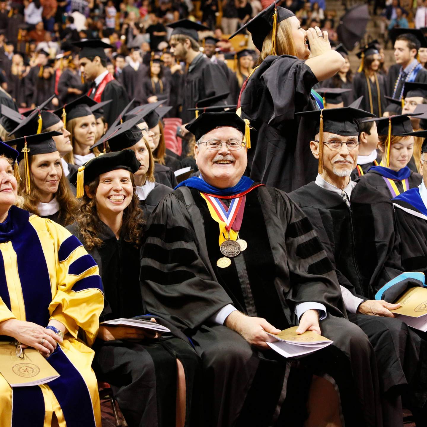 Excited staff and graduates during commencement ceremony 