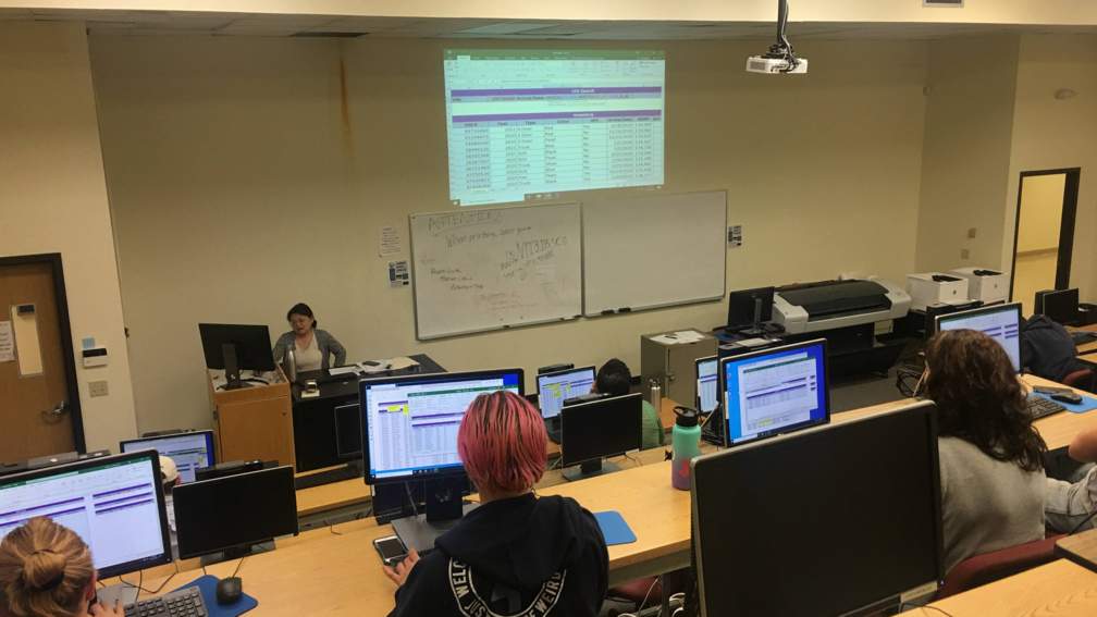 view of a lecture hall with students working on a statistical problem