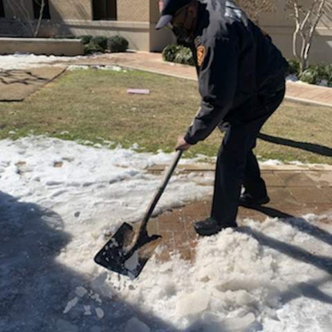 police officer shoveling snow