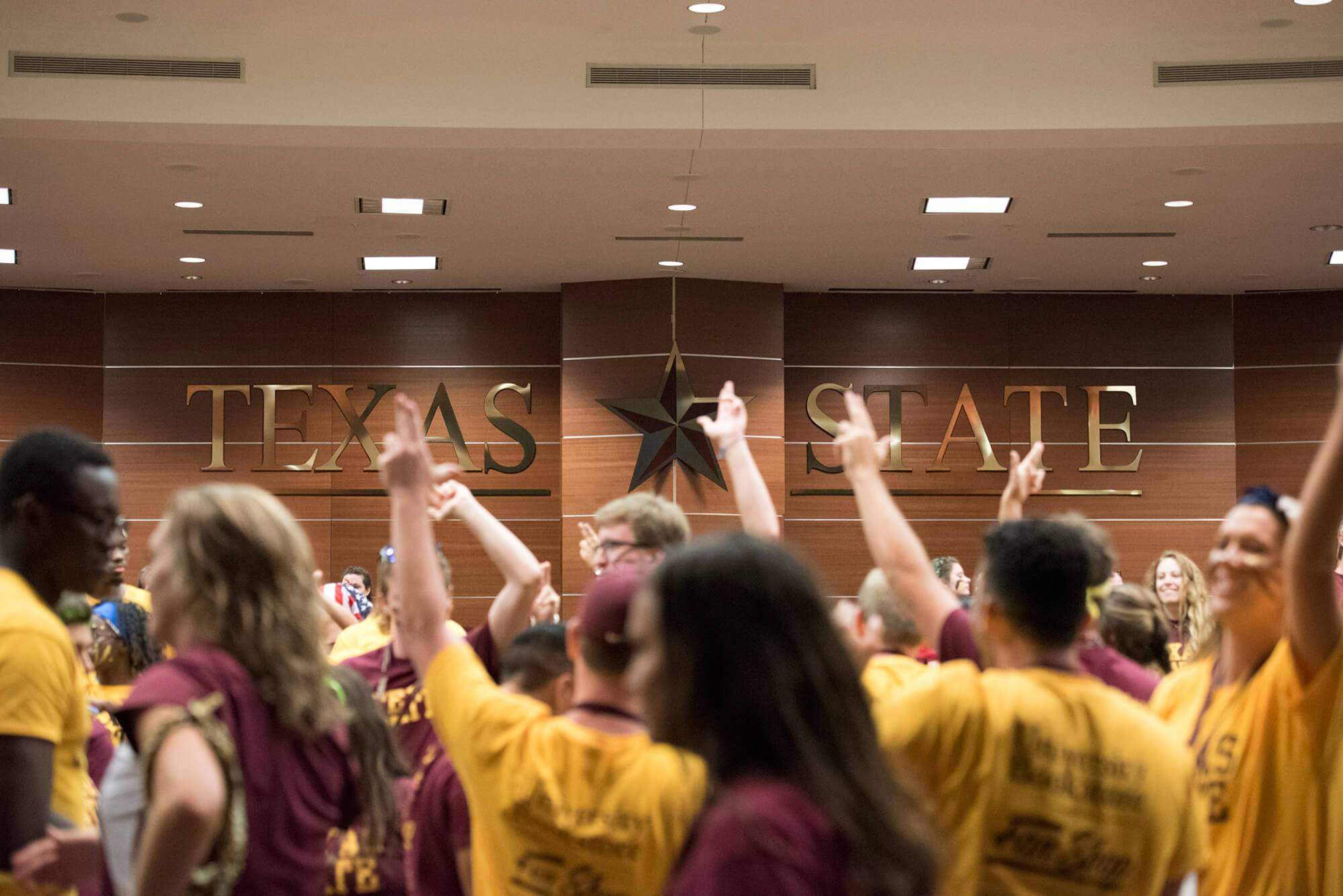 students showing TXST Pride Handsigns