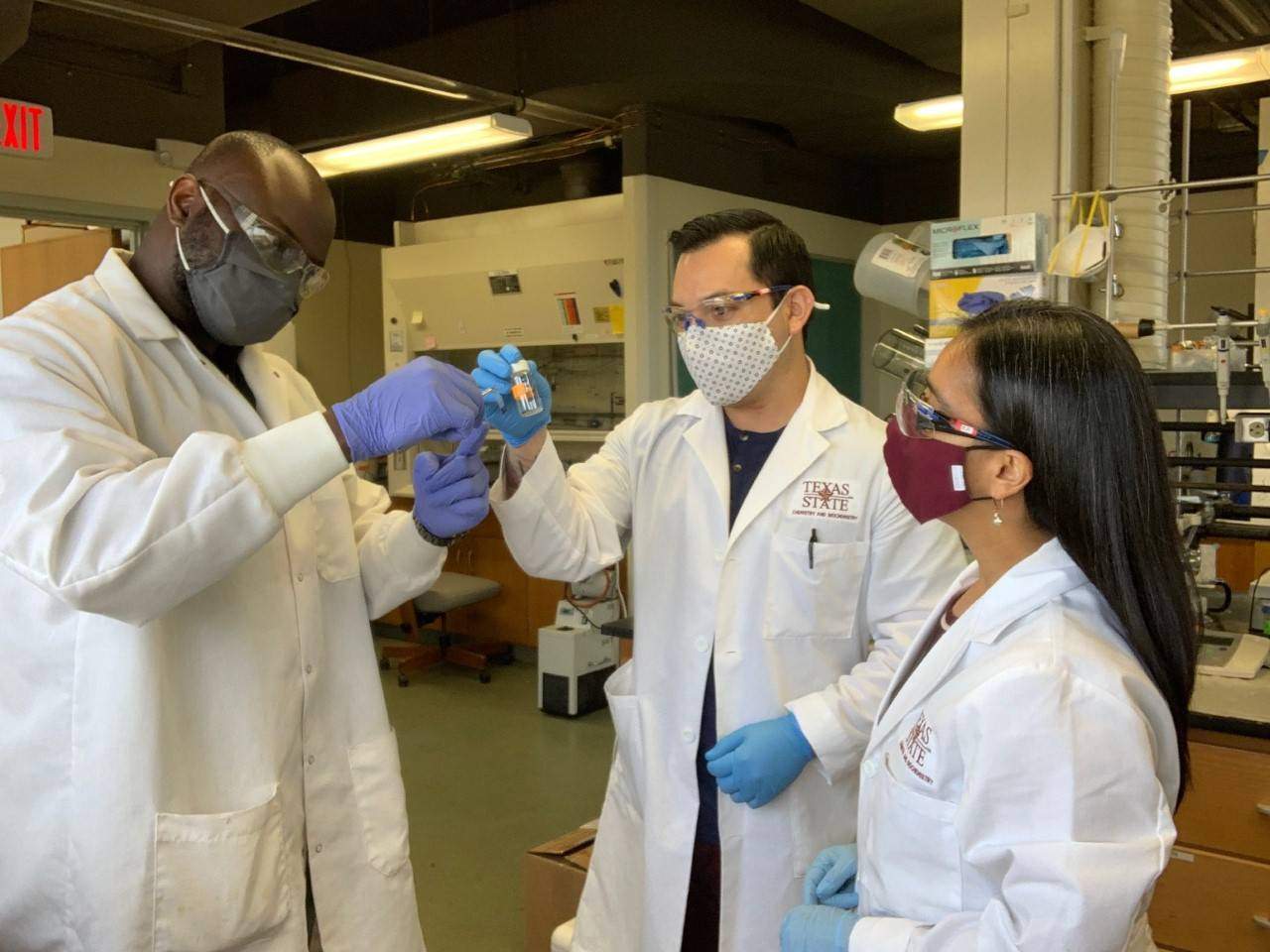 Dr. Betancourt with Damilola Runsewe (left), doctoral student in MSEC program, and Emilio Lara (middle), M.S. student in biochemistry, discussing observations of polymer samples.