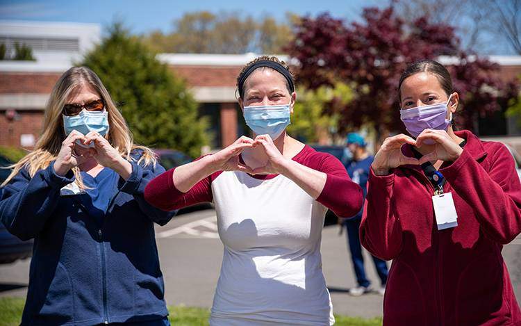 3 Nurses making heart shape with hands.