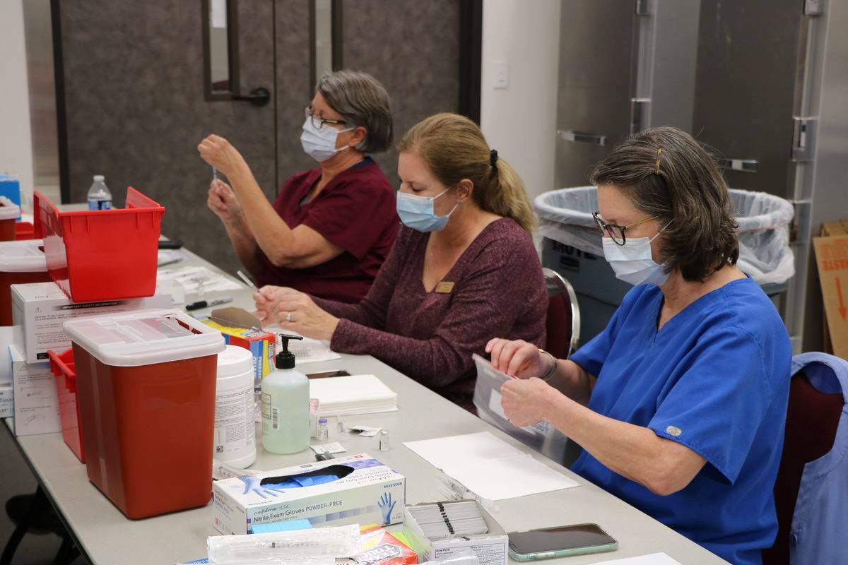 three women preparing vaccinations