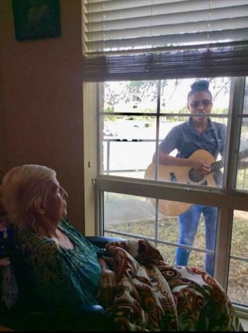 student playing guitar for woman in wheelchair