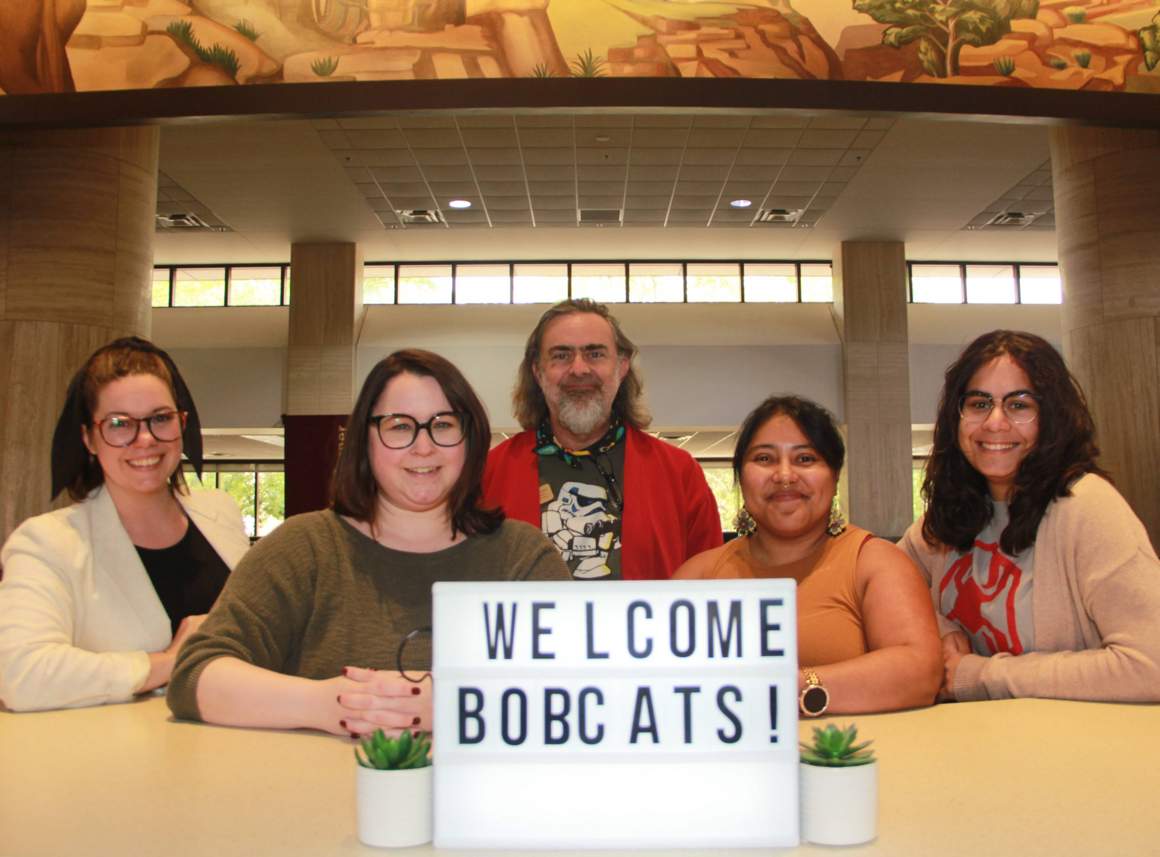 IUS Staff behind a sign that reads: Welcome Bobcats!