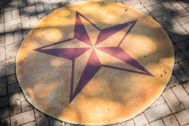 Texas State University star emblem on a round stone paver.