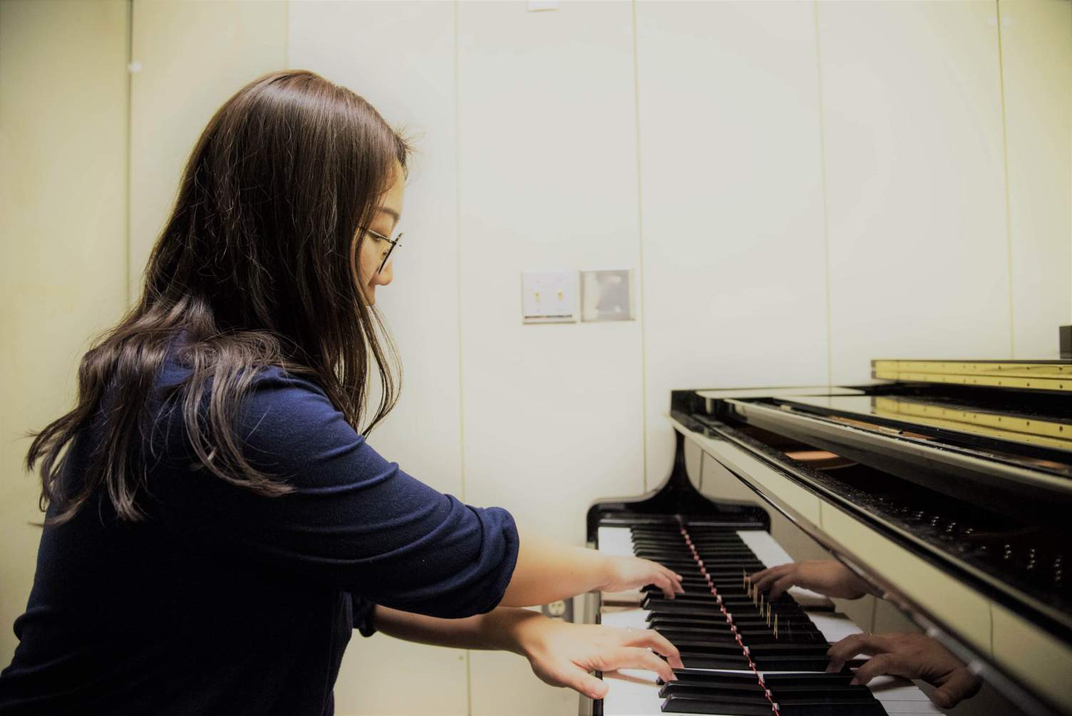 a female student plays the piano
