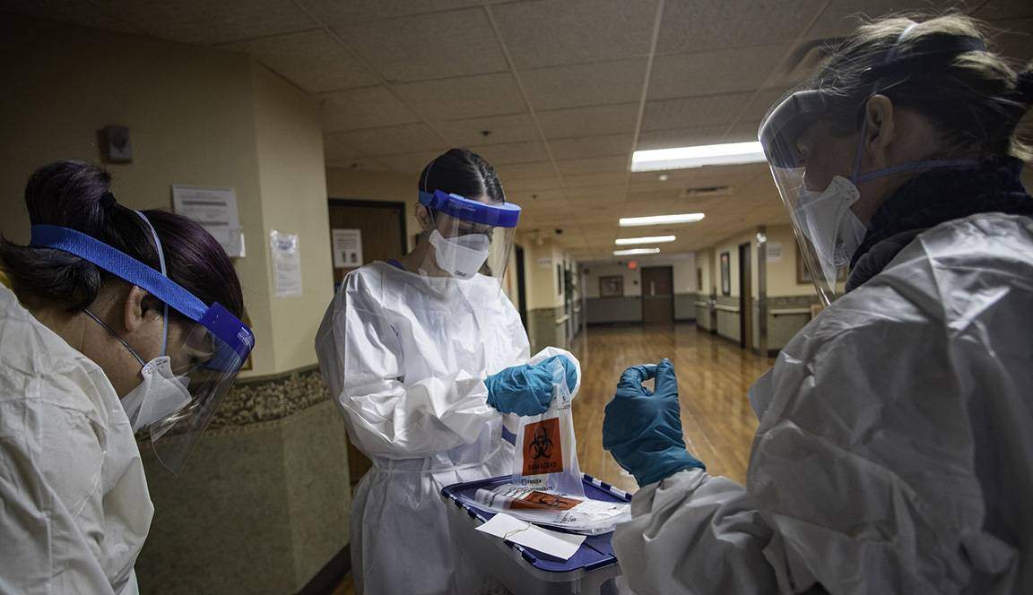 nurses in protective equipment conducting covid-19 tests