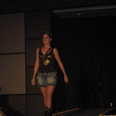 Female student/model wearing cowboy boots, jeans skirt and tank top.