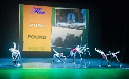 Dancers dancing infront of a screen 