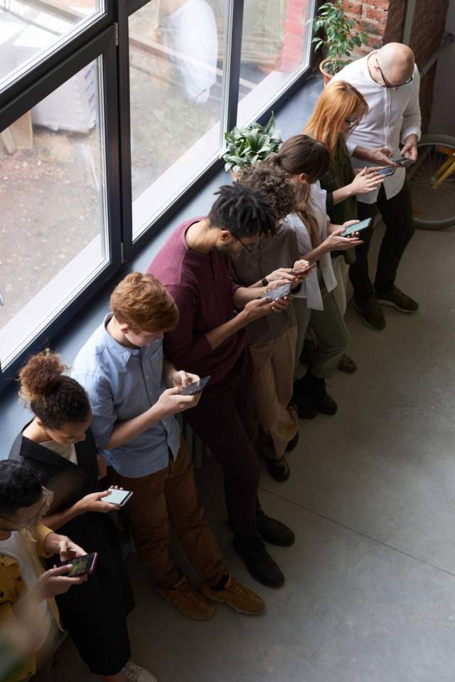 line of people on their smart phones