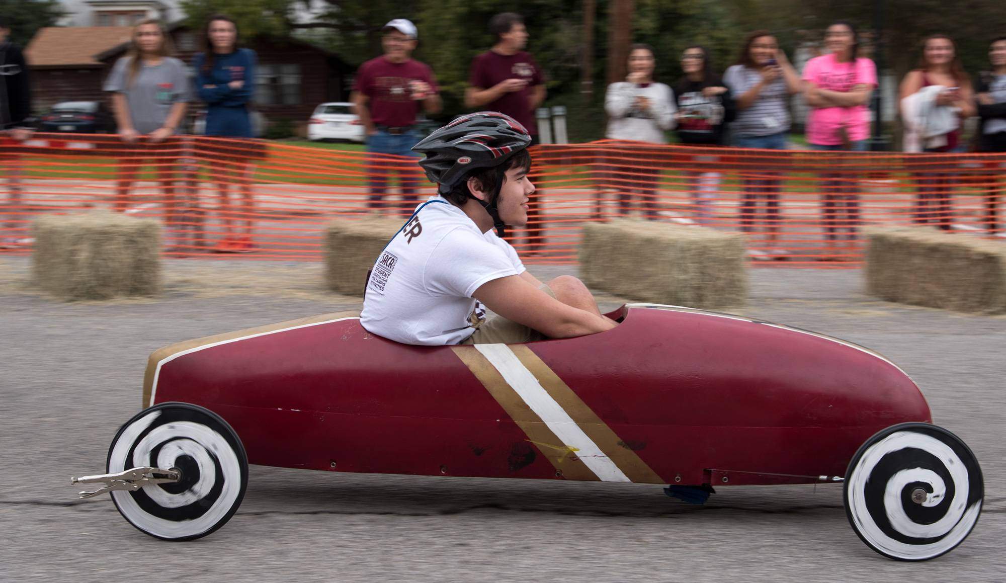 student sitting in soapbox derby car