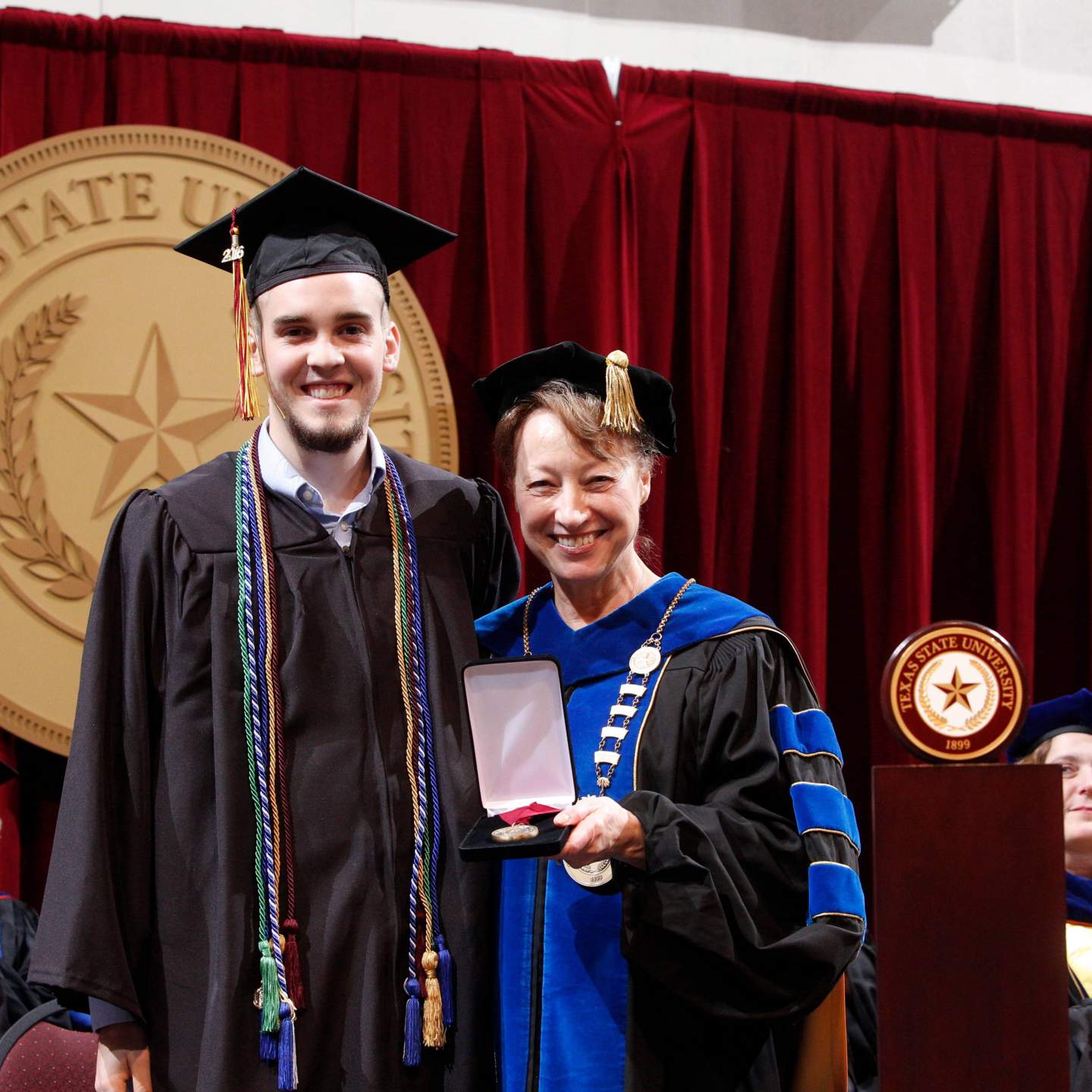 Mr. Hayden Marshal Payne receives the LBJ Outstanding Senior Student Award from President Denise M Trauth at a Spring 2016 Texas State University commencement ceremony.