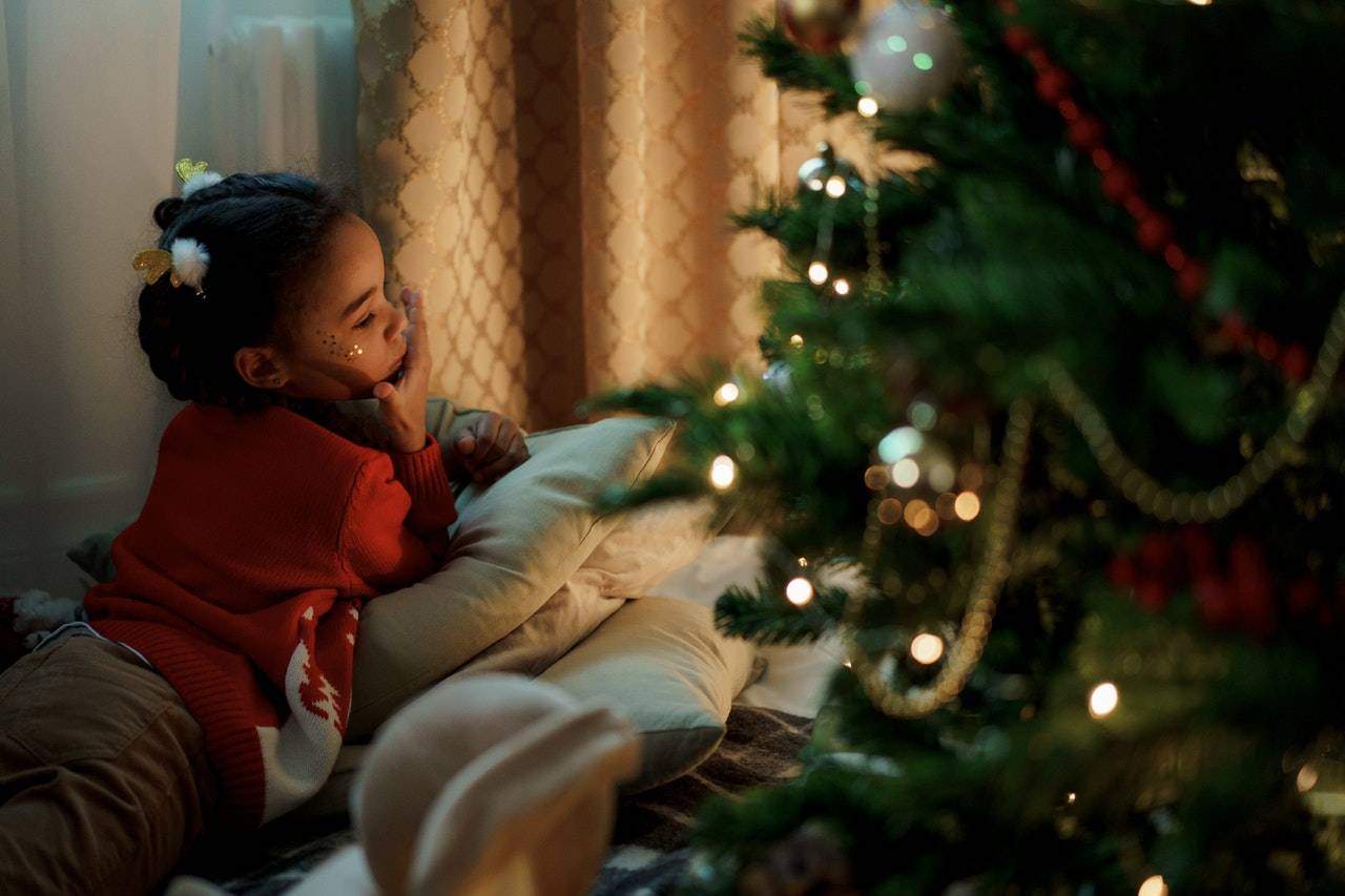young girl looking at christmas tree