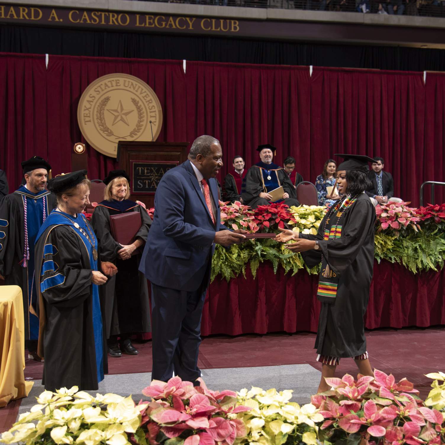 Senator West handing diploma to his niece (graduate)