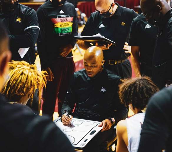 basketball coach talking to players during game