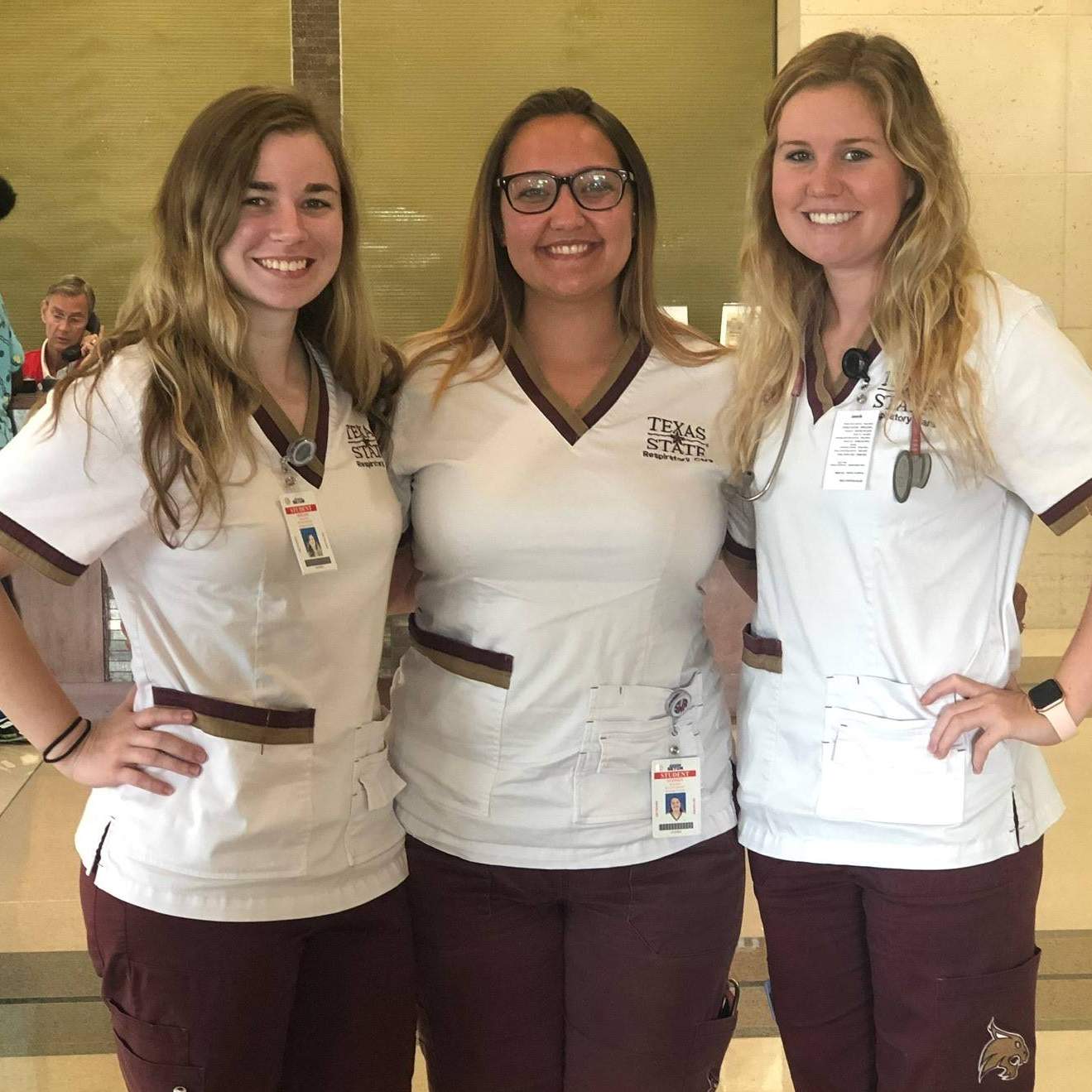 three women in medical scrubs smiling
