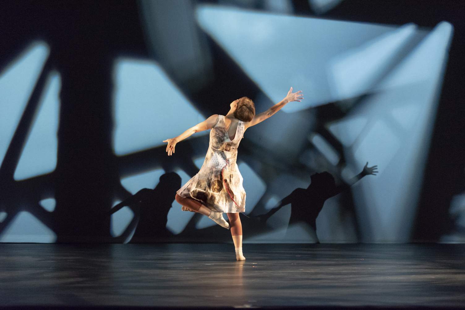 Dancer on stage at Texas State University with shadows behind them