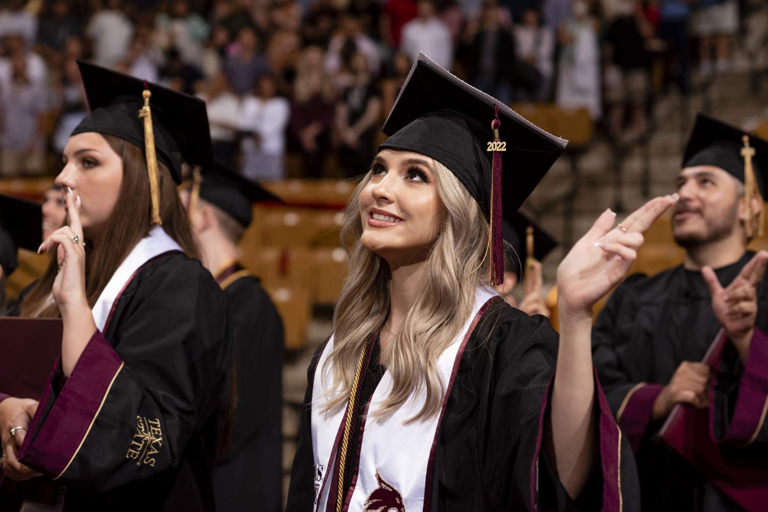 Grads holding up the show-em-state hand sign
