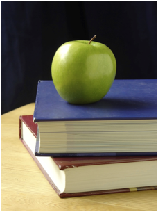 green apple resting on two school books