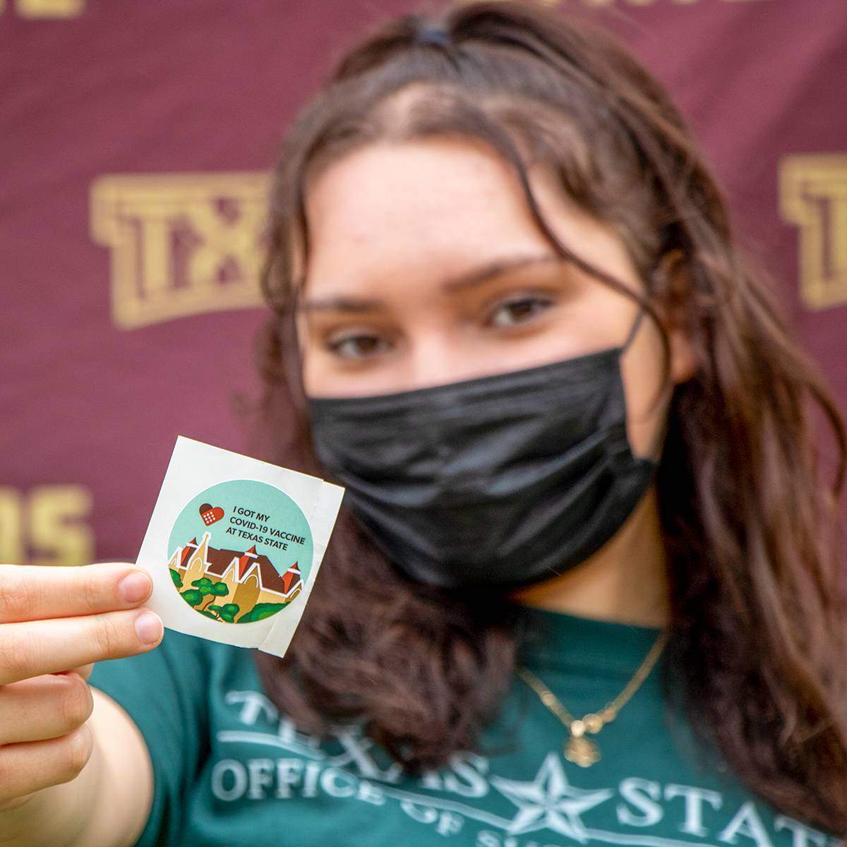 Student Posing with a COVID-19 vaccine sticker
