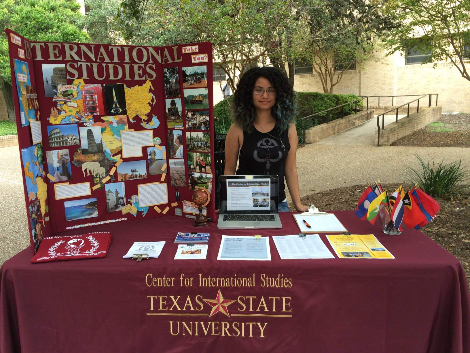 An International Studies student stands at a booth in the Texas State Quad
