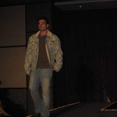 Male student/model walking down the runway at the fashion show.