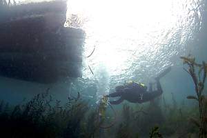 Texas State University underwater archaeologist Fritz Hanselmann operates a core tube with pneumatic post driver in Spring Lake.