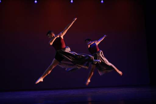 Two dancers on stage leaping