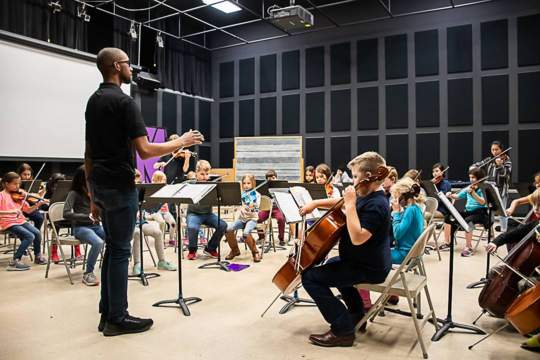 Student teacher conducting string students