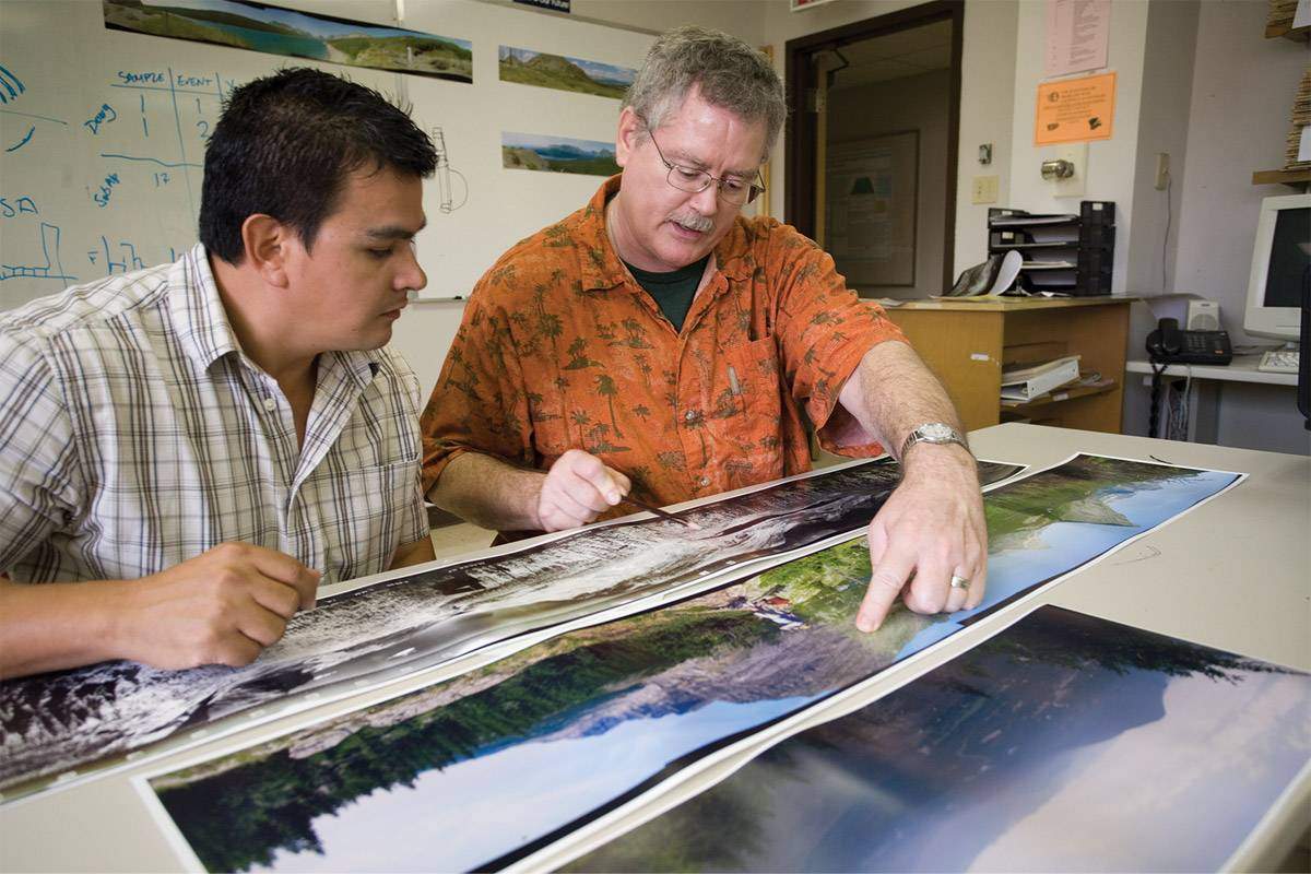 two men analyzing geographic pictures
