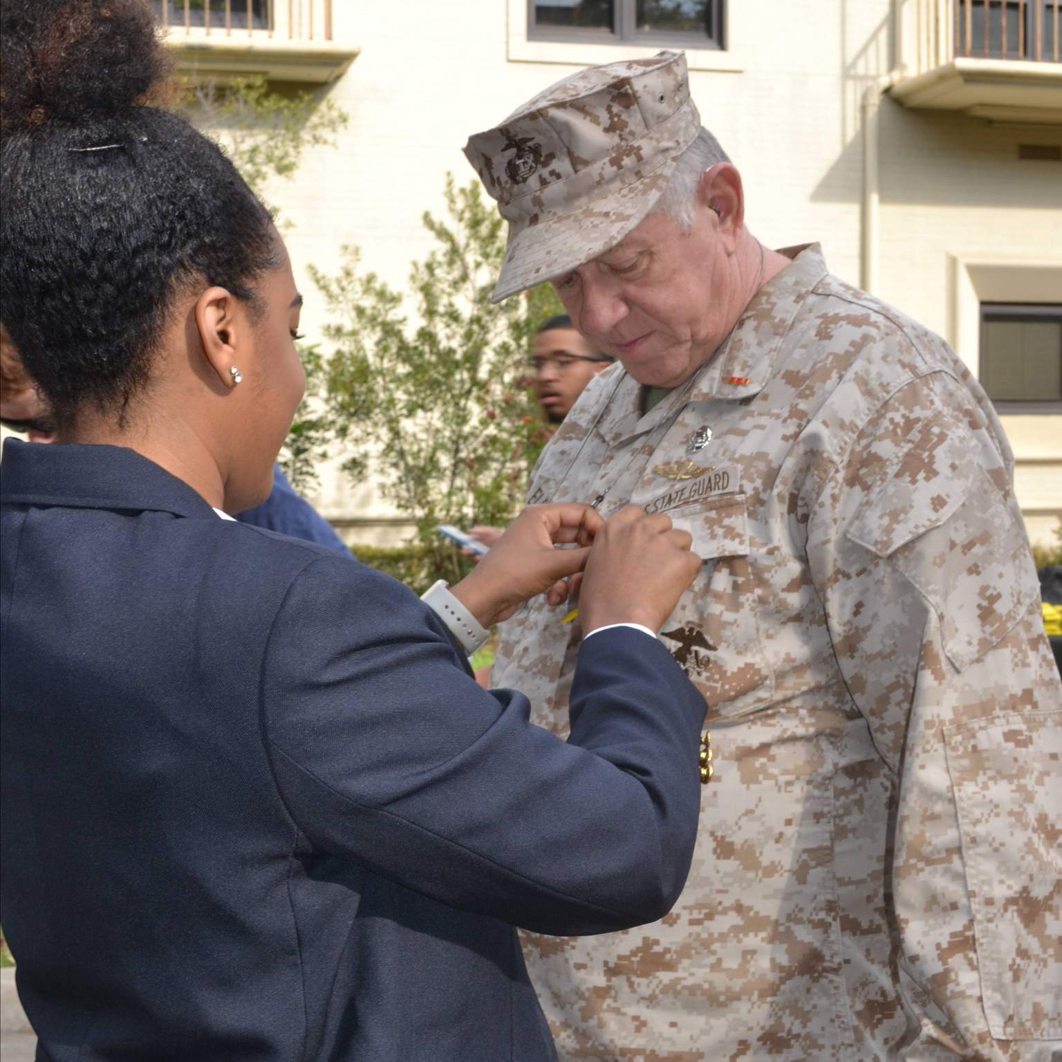 SF member pins ribbon on Veteran and faculty member