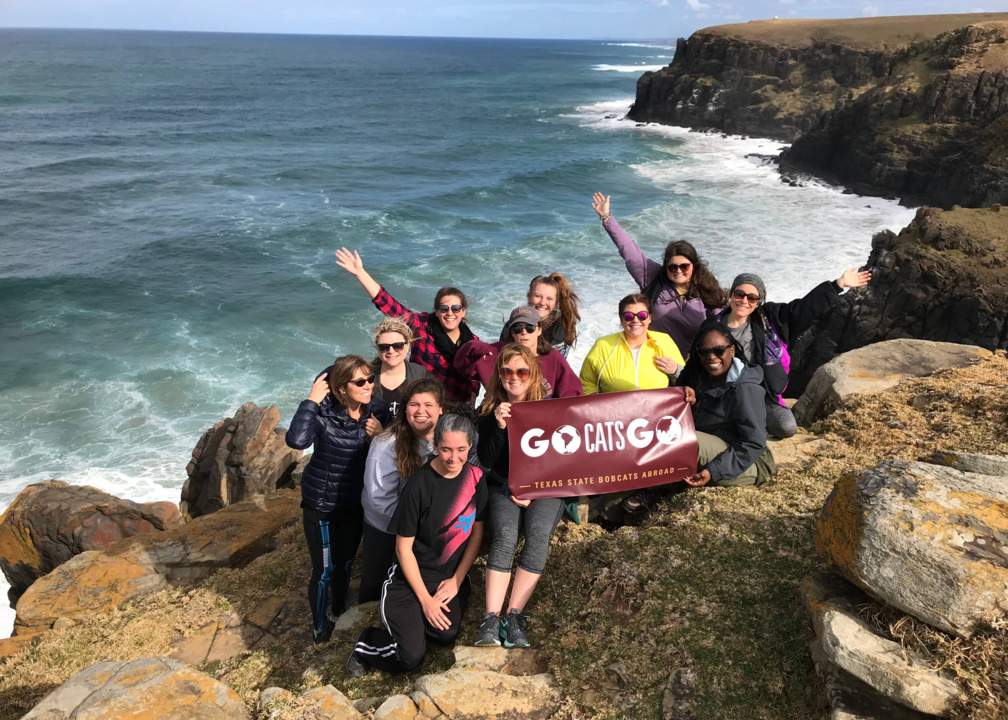 Assaf's 2018 study abroad class holding a Bobcats banner at Morgan Bay in South Africa's Eastern Cape