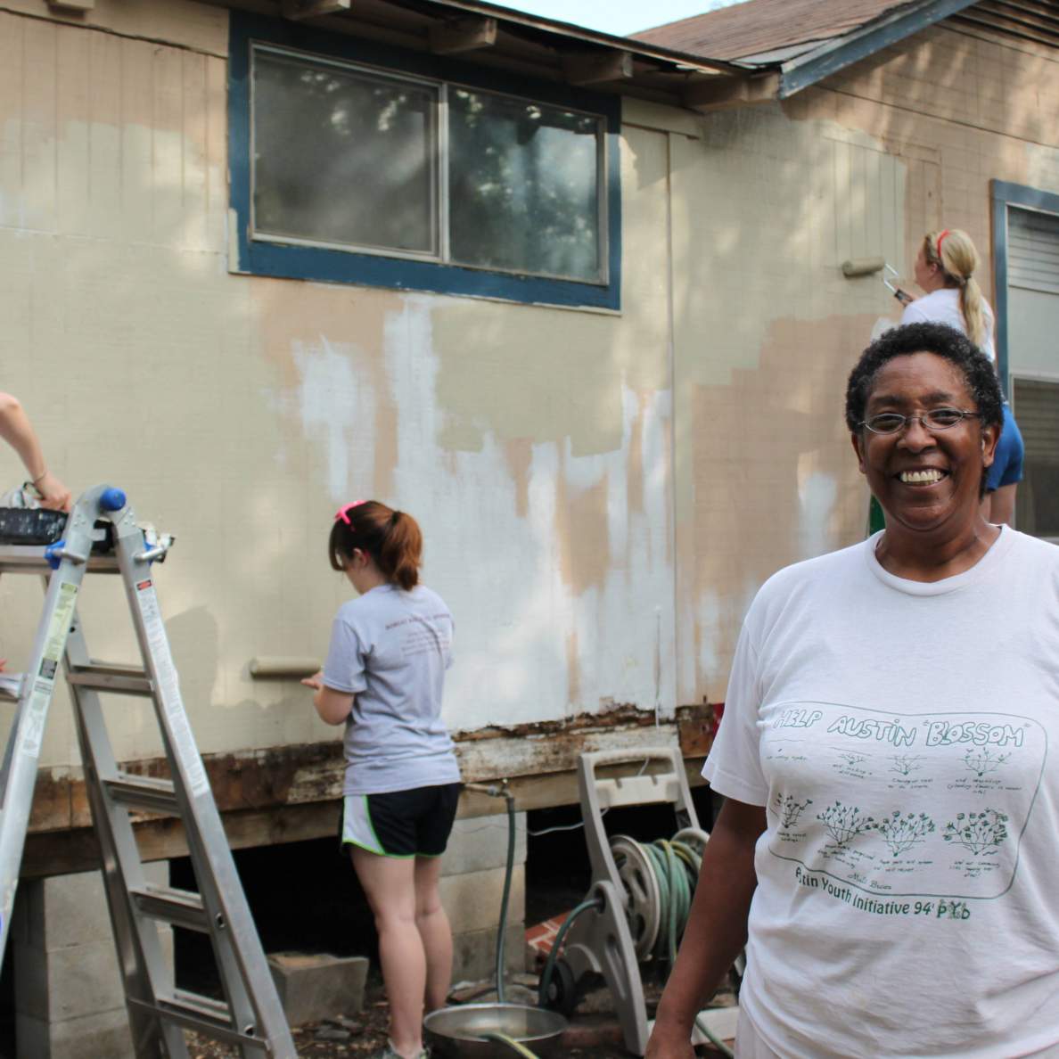Volunteers paint a building.