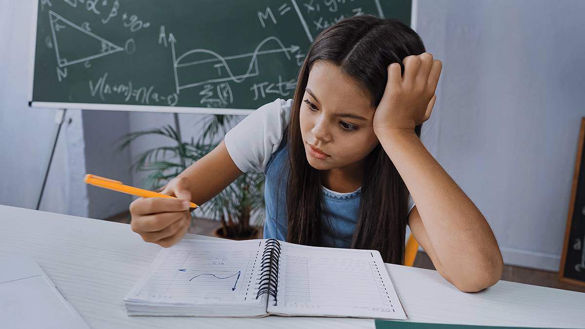 middle school student looking at graph on notebook paper
