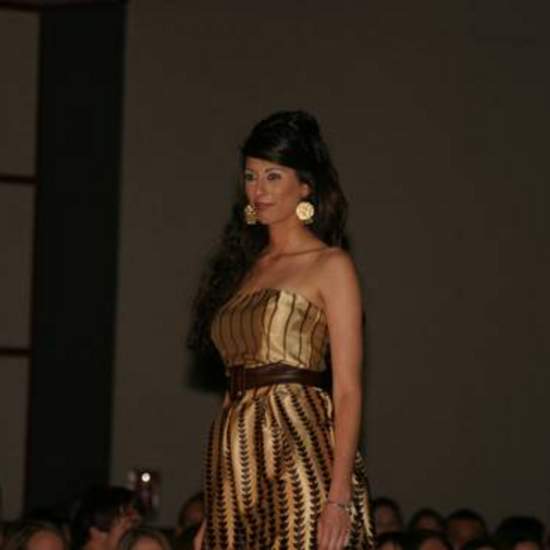 Student wearing gold strapless dress with brown print and a brown belt 