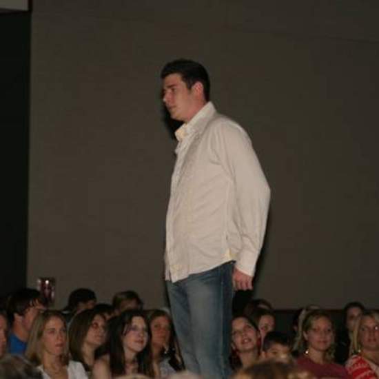 Student wearing dress shirt over jeans and loafers at the fashion show.